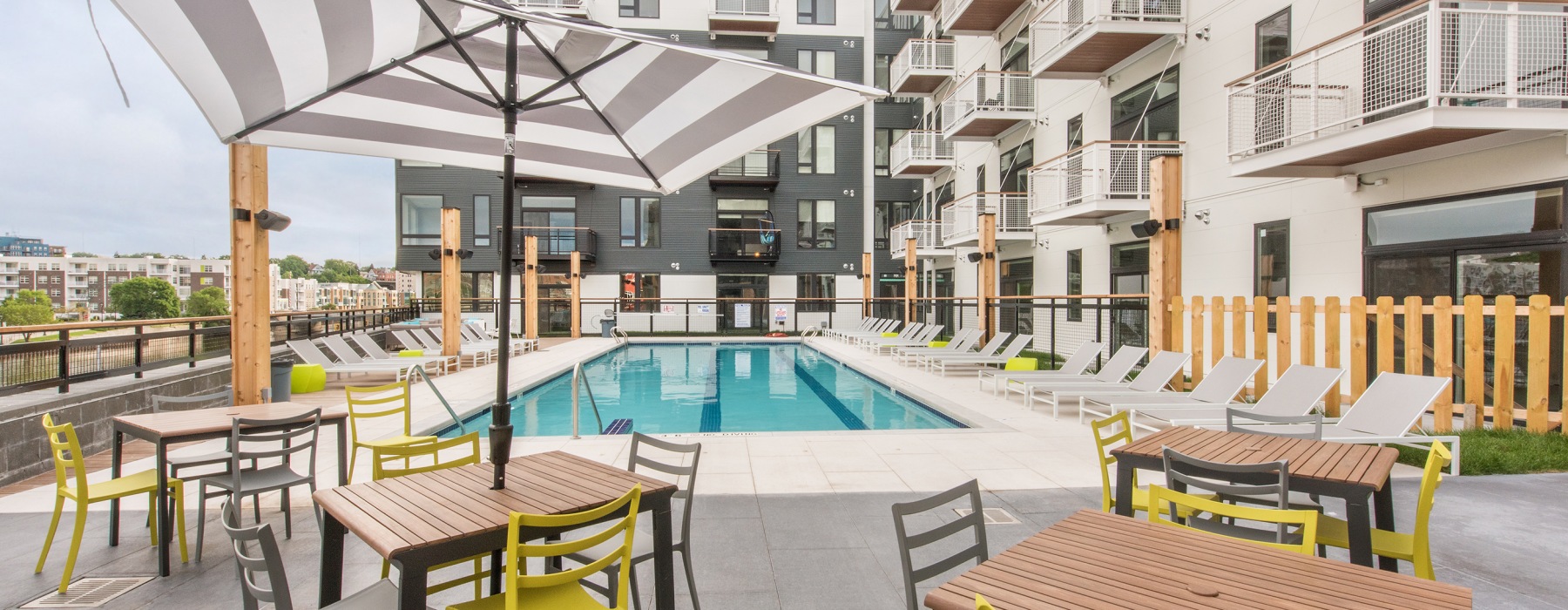 Resort-style apartment pool with lounge chairs and cabanas